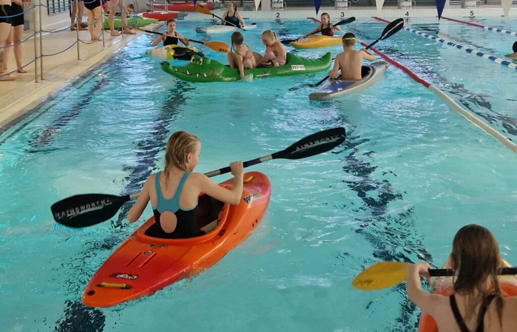 Lapsia kokeilemassa melontaa uimahallilla